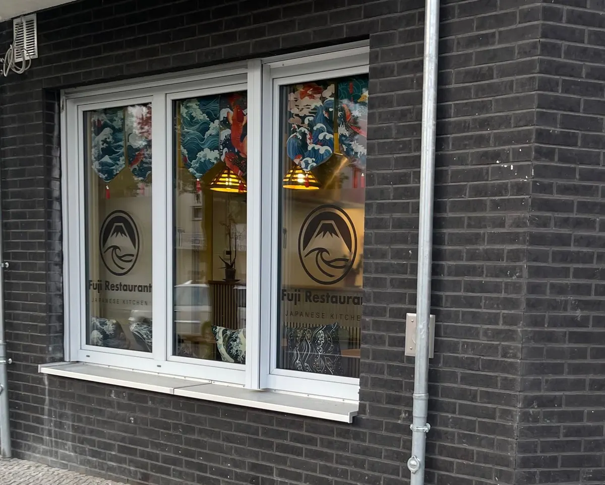 Fenster mit dem Fuji-Logo, von der Straße aus
